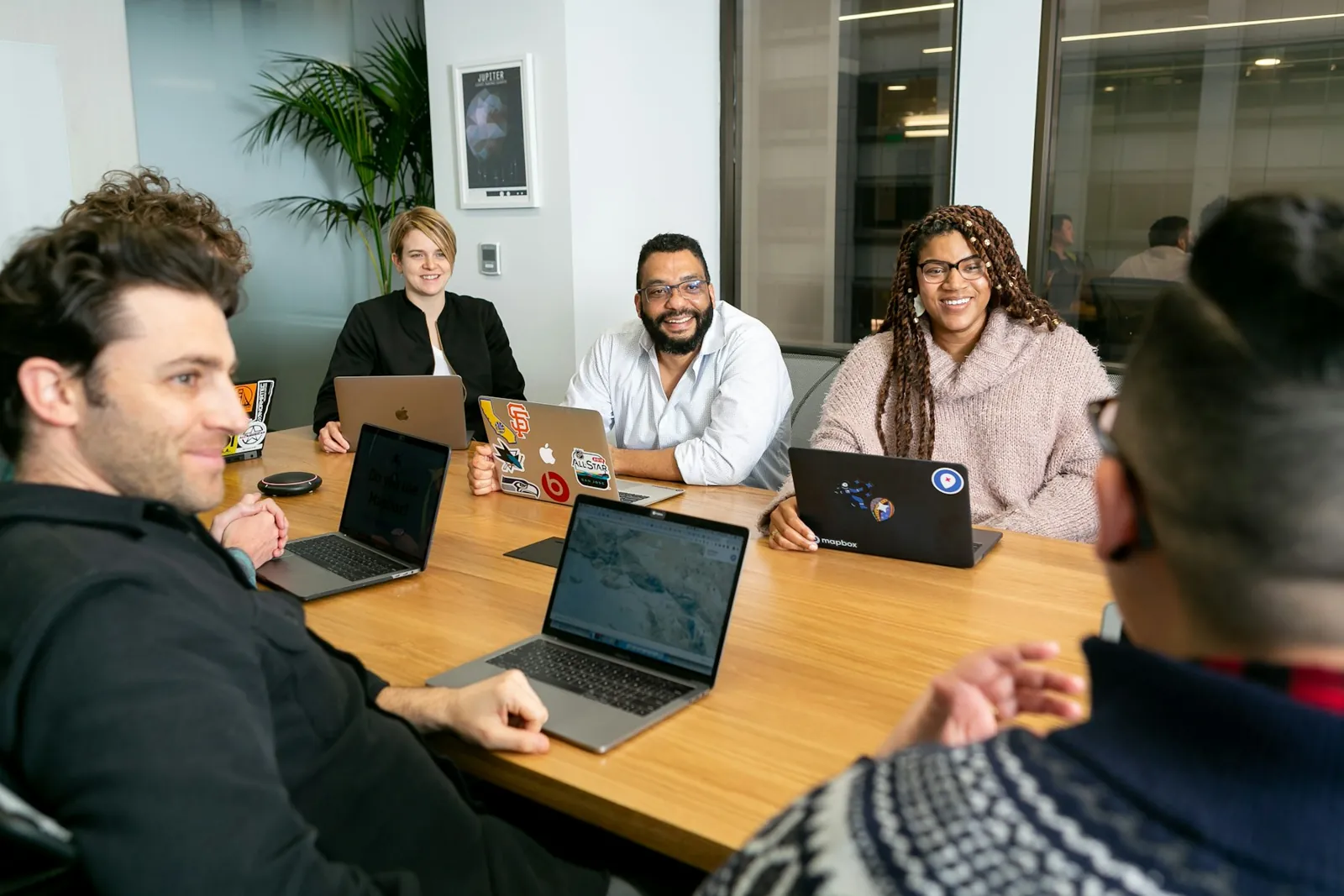 Equipo de trabajo en reunión con sus portátiles